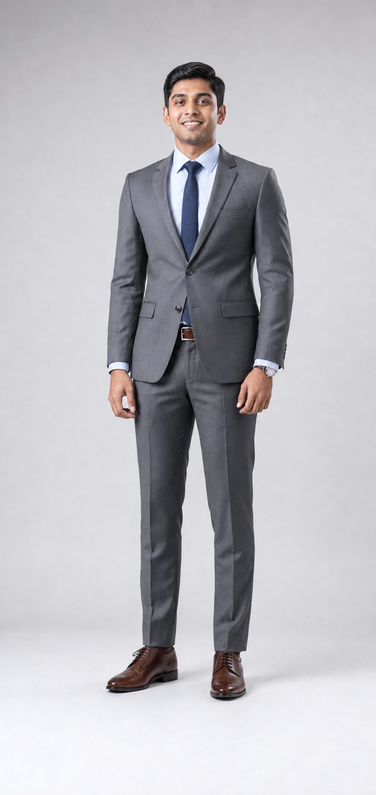 Man in a charcoal grey suit, light blue shirt, navy tie and brown laced shoes: Business Formal attire