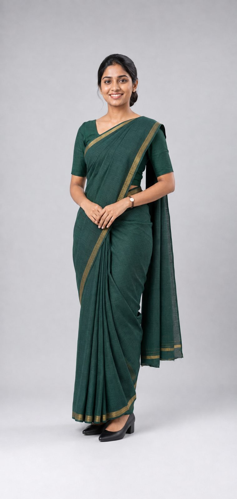 Woman in a dark green cotton saree with a gold border, matching short-sleeved blouse and black block-heel court shoes: Business Formal attire in Sri Lanka